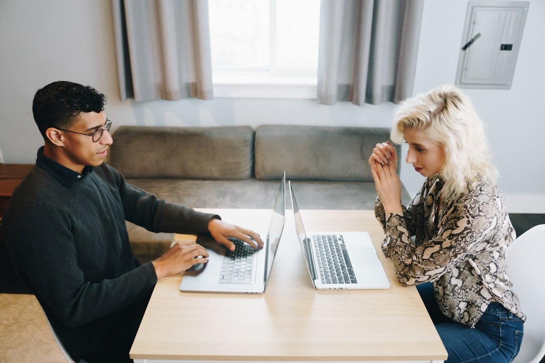 Two colleagues discussing a project over a laptop